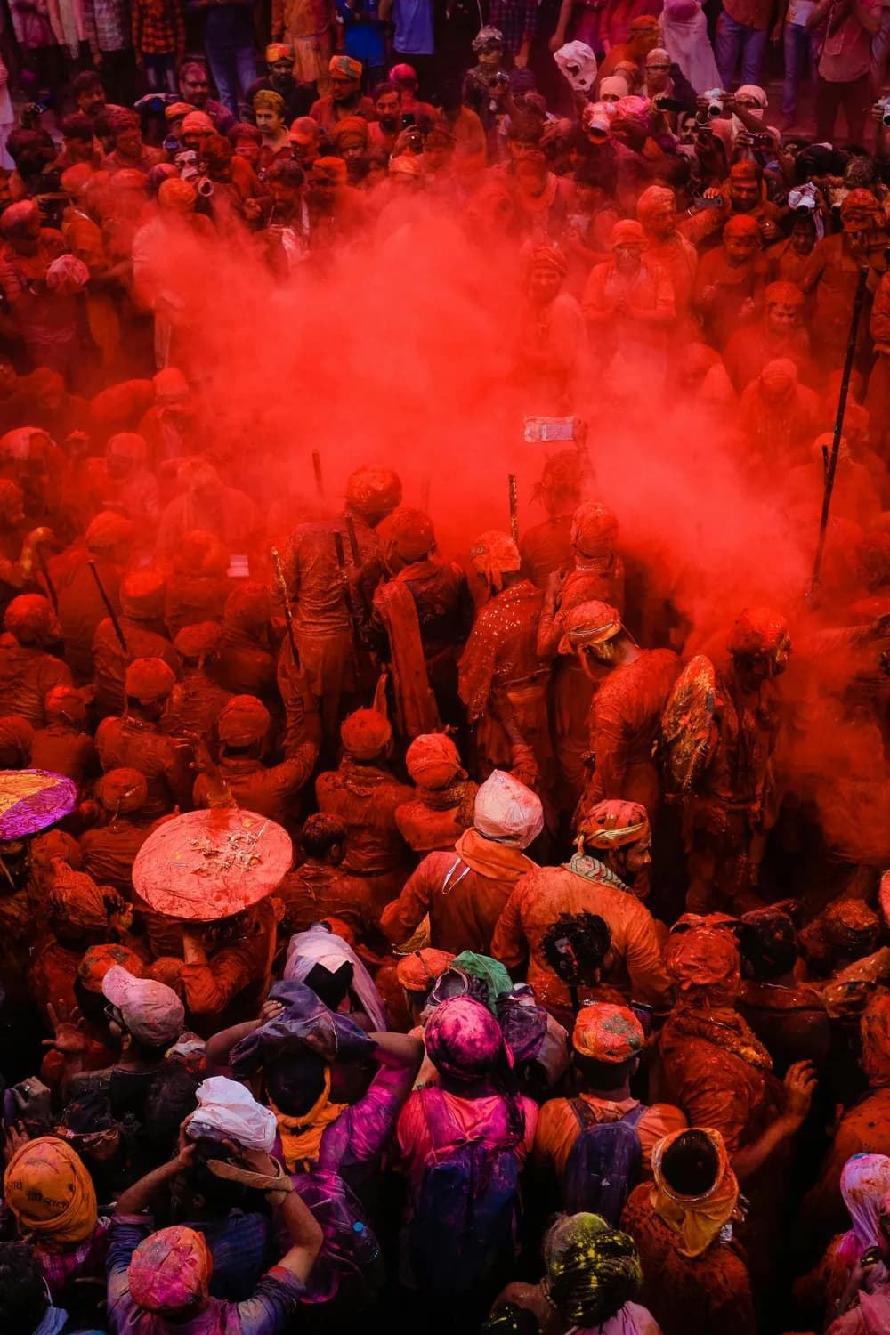 Multitud cubierta de polvo rojo durante el Holi Festival